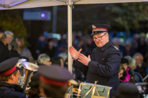 Male in Salvation Army Uniform standing in front of band 