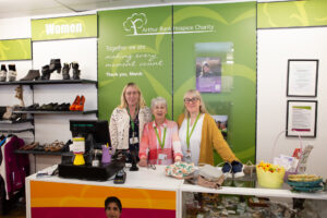 3 females standing behind a counter