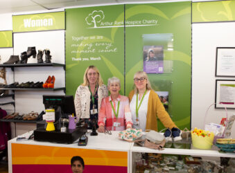 3 females standing behind a counter