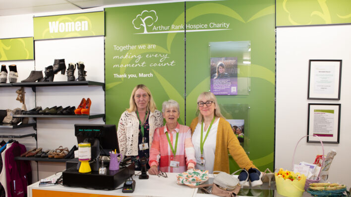 3 females standing behind a counter