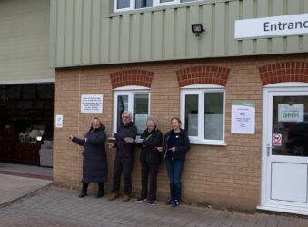 Males and females standing outside a warehouse