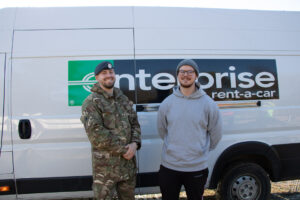 2 males standing in front of a van 