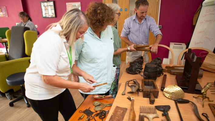 2 Females and one male looking at objects on a table