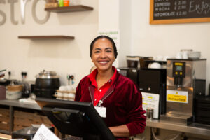 Female standing behind a till