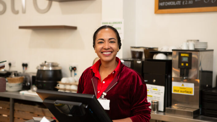 Female standing behind a till