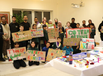 Group of adults and children holding colourful banners