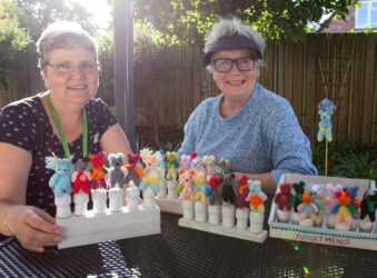 2 females in the garden holding miniature bears