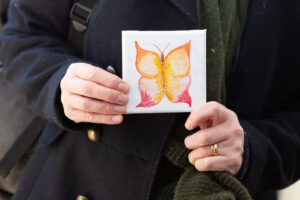 Orange butterfly painting and hands holding the canvas