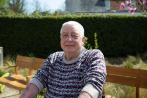 Male wearing a jumper in the garden, looking at the camera