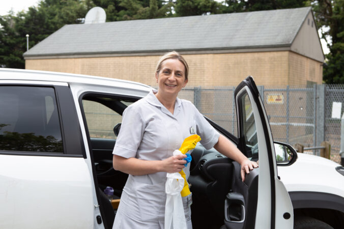 Nurse standing in front of a car