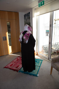 Female wearing black dress and scarf
