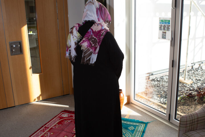 Female wearing black dress and scarf
