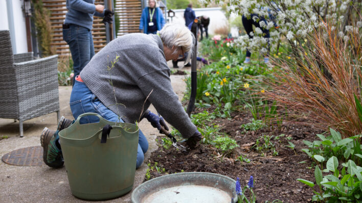 Female gardener kneeling at a garden