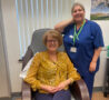 female sitting in a chair and female nurse standing next to her