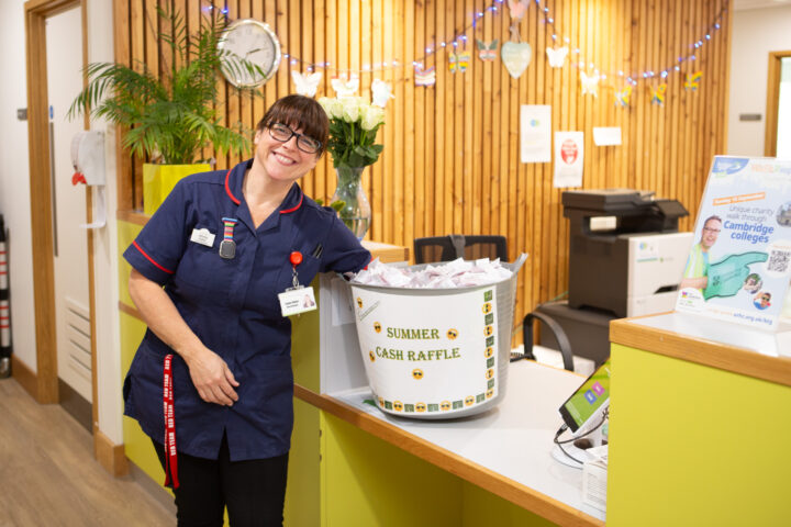 Female nurse smiling at the camera with a large summer raffle bucket