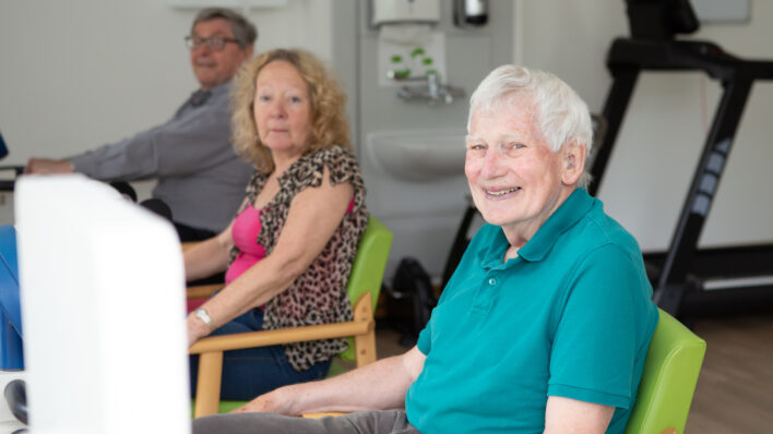 Male sitting in a chair smiling at the camera