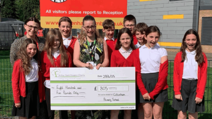 Students in red outside Cottenham Primary school sign