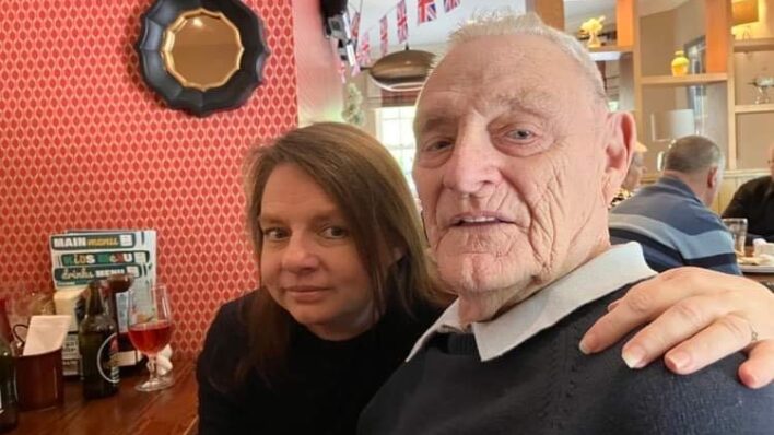 Female with brown hair smiling at camera with elderly father
