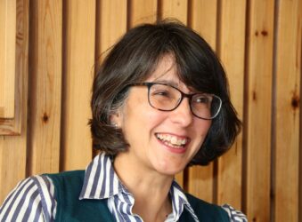 Female wearing glasses, smiling.