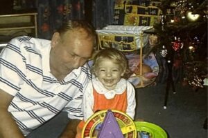 Man with young girl on the floor by a xmas tree