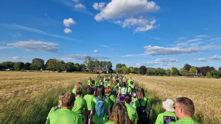 Walkers wearing green and blue sky