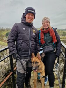 outdoors man and woman with Alsatian