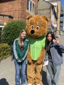 Charity mascot Arthur bear outside with 2 female 16year olds