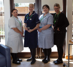 Four women, three in nurse uniform.