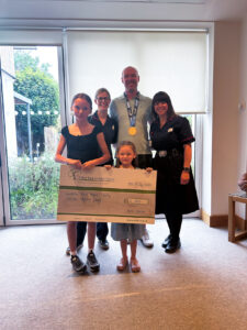 Nurses, male and children with large cheque