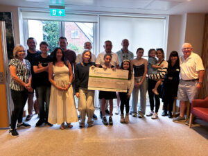 Nurses, male and children with large cheque