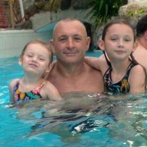 Male in swimming pool with two children