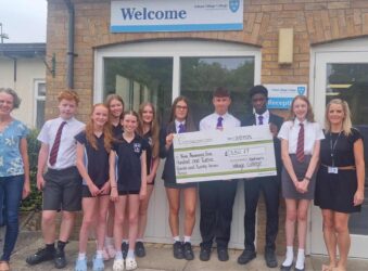 Male and females students holding a large cheque.
