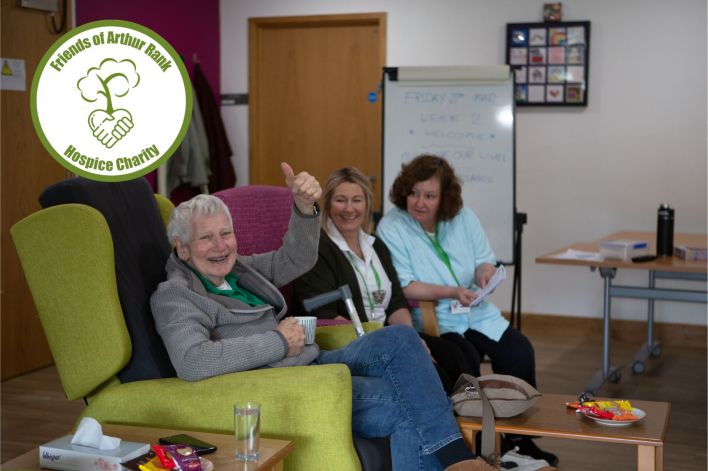 Male and 2 females sitting in a chair - thumbs up