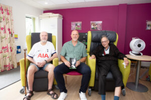 3 males sitting in chairs looking at the camera 