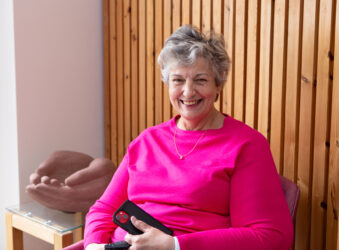 Female wearing pink smiling at the camera