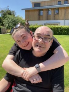 Female with her arms around a male in a garden
