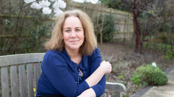 Female sitting on a bench looking at the camera