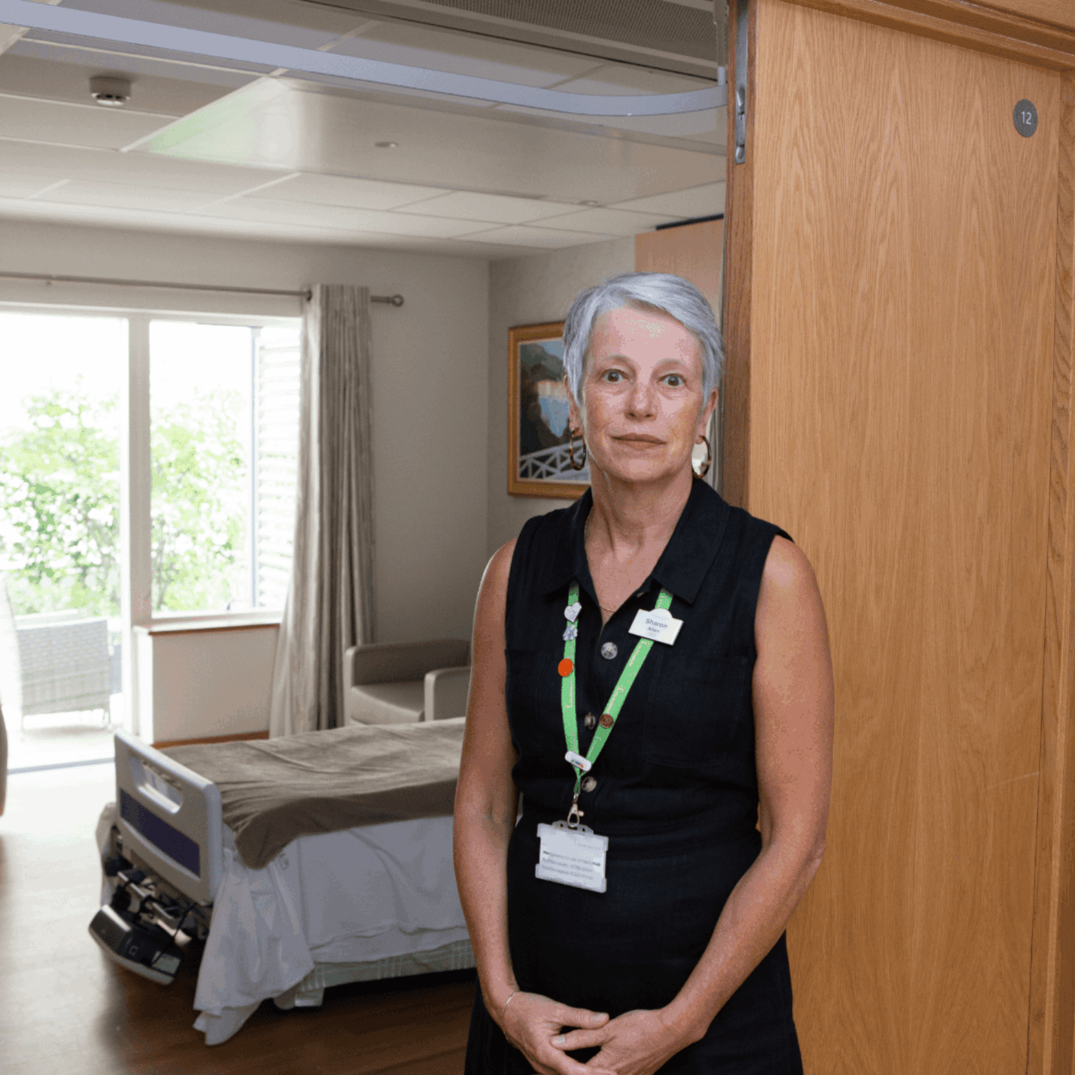 Female standing near a bed