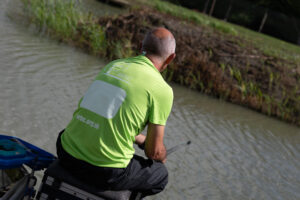 Male in green t-shirt fishing outside 