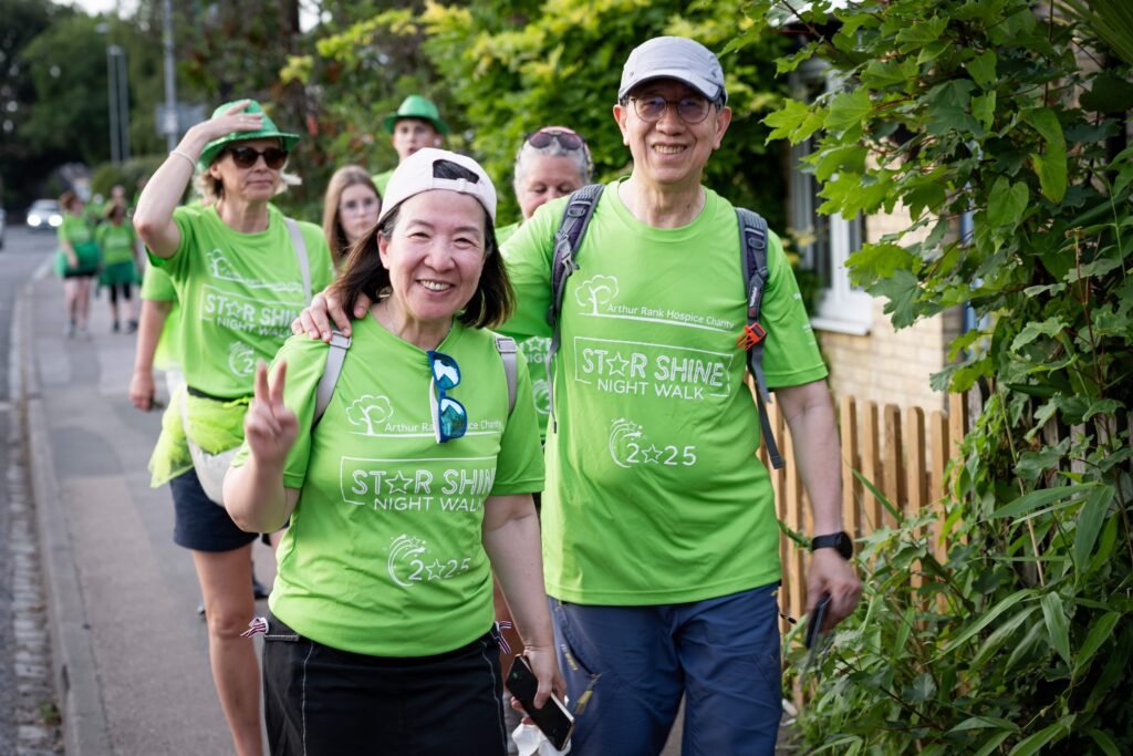 Group of walkers with a man and lady leading at the front. All are wearing bright green star shine tshirts.