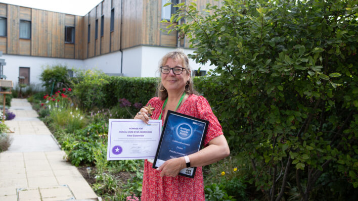 Female holding awards outside a large building