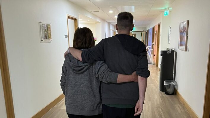Man and woman picture from behind walking in Arthur rank Corridor