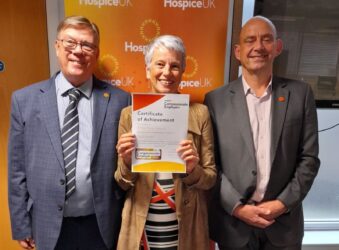 2 males a female holding a certificate