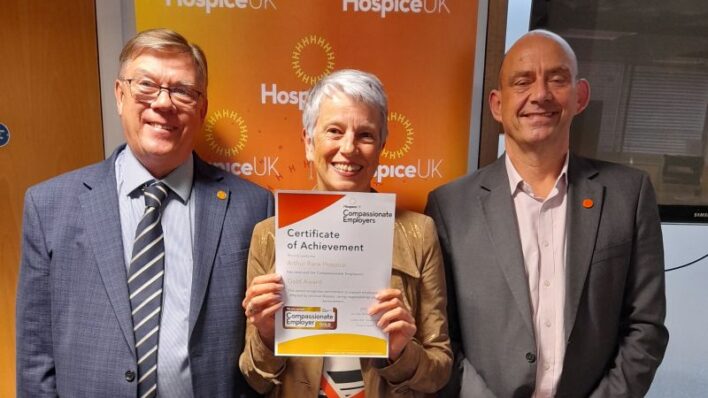 2 males a female holding a certificate