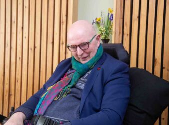 Male wearing blue sitting down