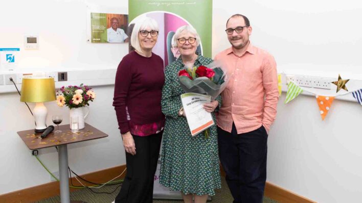 2 female and a male with certificate and flowers