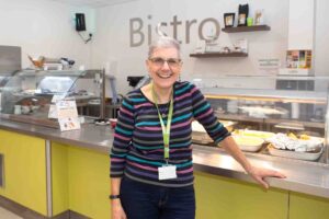 Female standing near a Bistro hatch and sign