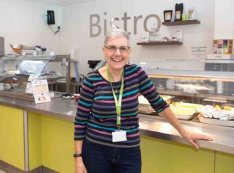 Female standing near a Bistro hatch and sign