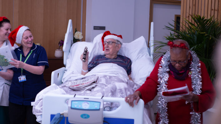 Male in bed with Christmas Hat