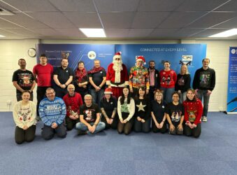 Group of adults wearing Christmas jumpers